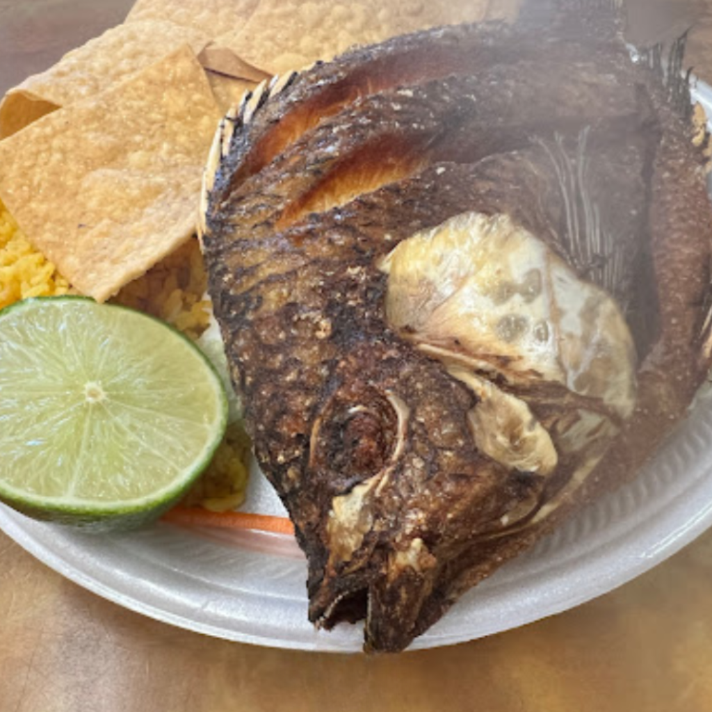 Authentic Mexican mojarra dish served at Taqueria Los Compadres, complete with side of rice, tortilla chips, and a slice of lime.