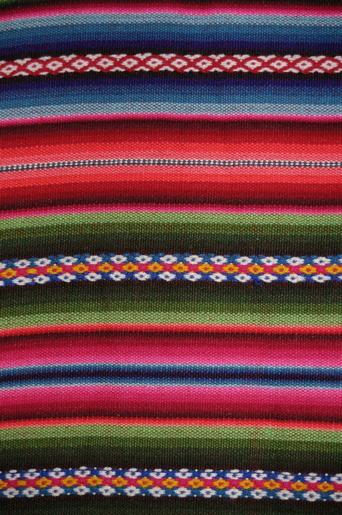 Colorful traditional Mexican poncho highlighting cultural ties at Taqueria Los Compadres.